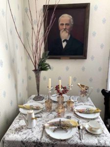 Painting of Alexander Faribault and small table set for the holidays.